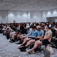 a large group of people sitting in a conference room